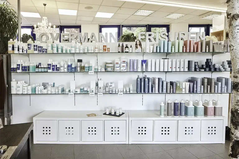 Ein weißes Regal mit Pflegeprodukten im Friseursalon von Overmann Frisuren