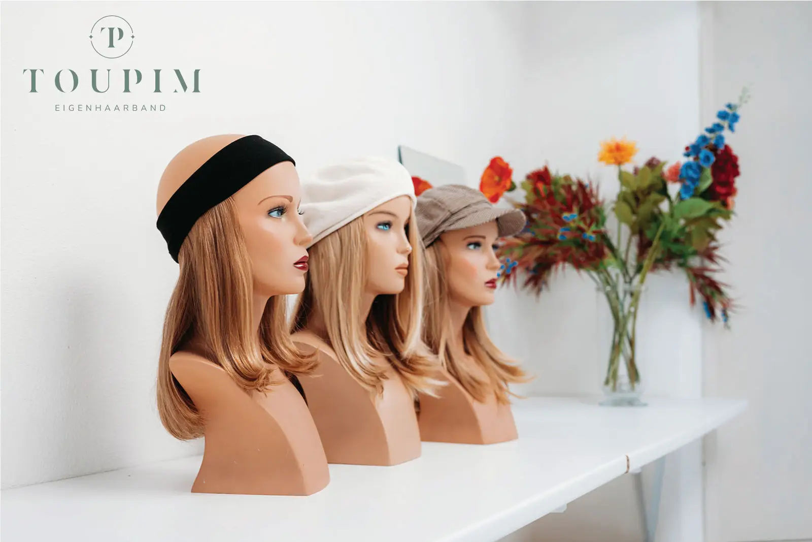 Drei Toupim-Eigenhaarbänder mit Stirnband und Mützen sind auf drei Büsten auf einem Regal arrangiert