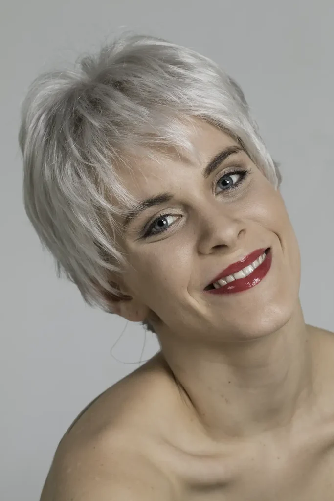 Model, das mit der Belle-Madame-Perücke „Light Mono SF“ mit geneigtem Kopf in die Kamera blickt