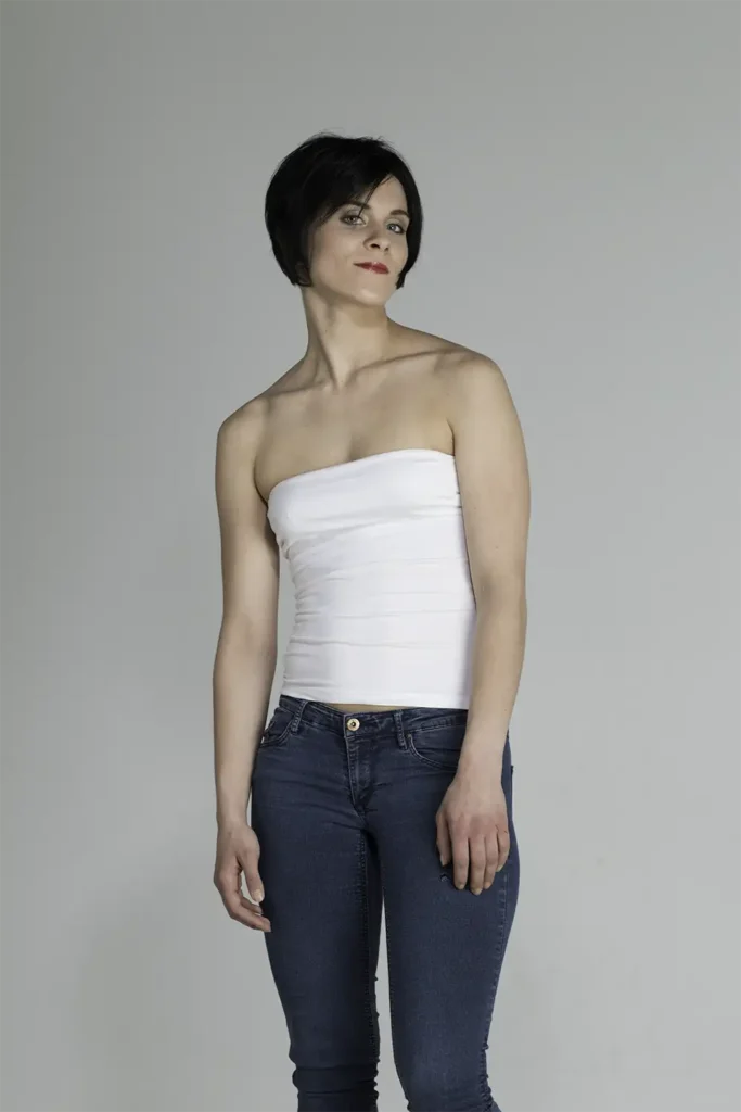 Model, das mit der Belle-Madame-Perücke „Vicky Mono SF“ in Mocca mit seitlich gedrehtem Kopf die Kamera blickt