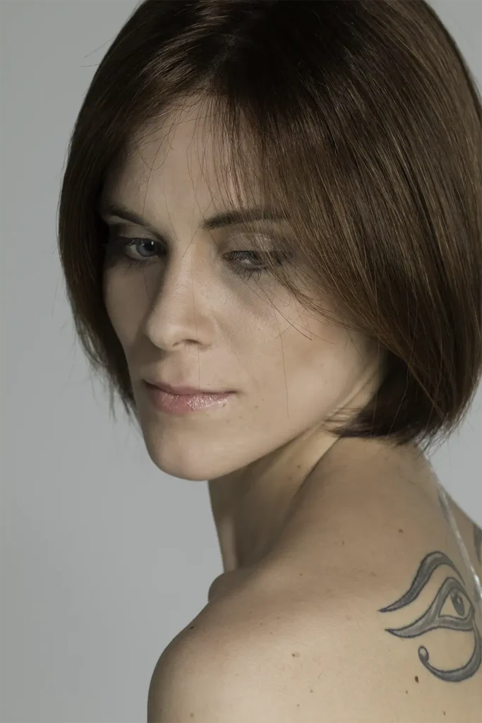 Model, das mit der Belle-Madame-Perücke „Amanda Mono SF“ in Chocolate seitlich gedreht zur Kamera steht und den Blick schräg Richtung Boden richtet