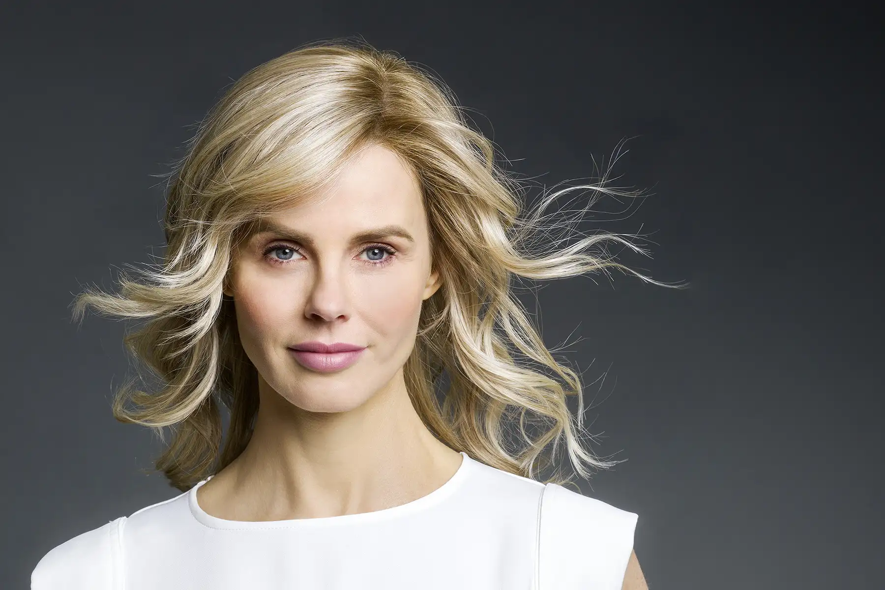 Model, das die Belle-Madame-Perücke „Alma HI SSF“ in Nordic Ash Blond trägt und in die Kamera schaut