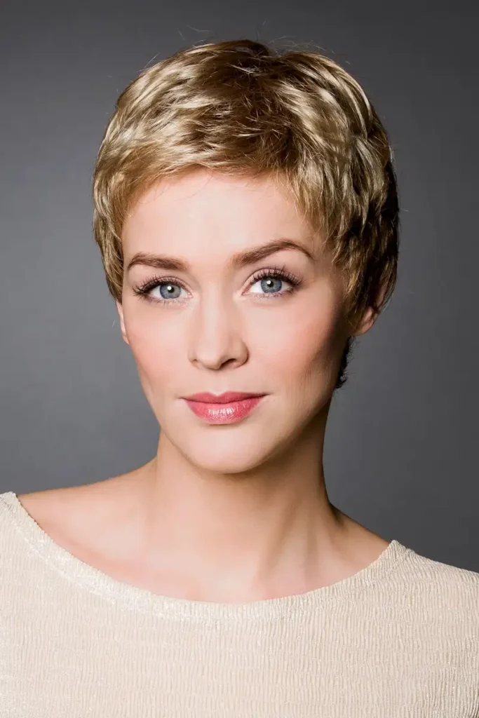 Model, das die Belle-Madame-Perücke „Ebba SF“ in Sandy Blond Root trägt und in die Kamera schaut