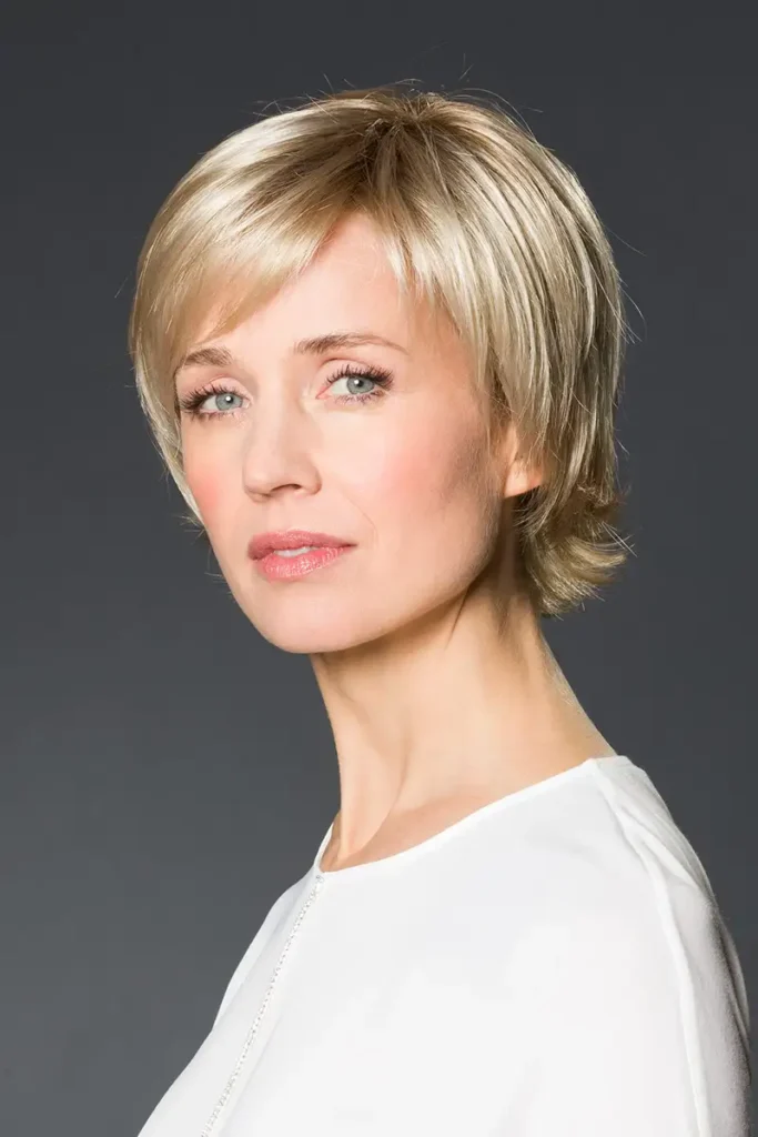 Model, das die Belle-Madame-Perücke „Tilda Soft SF“ in Nordic Ash Blond trägt und seitlich in die Kamera schaut